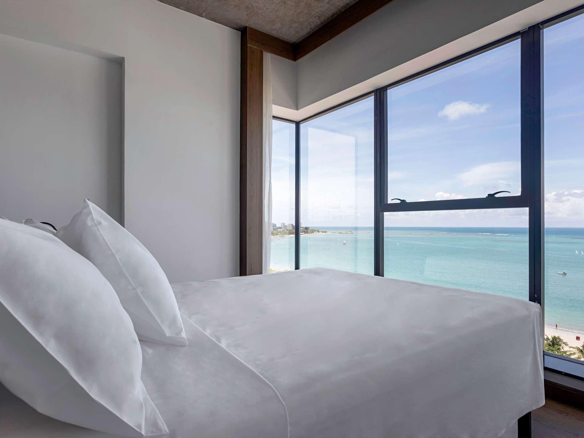 Quarto com 1 cama de casal e vista lateral mar
